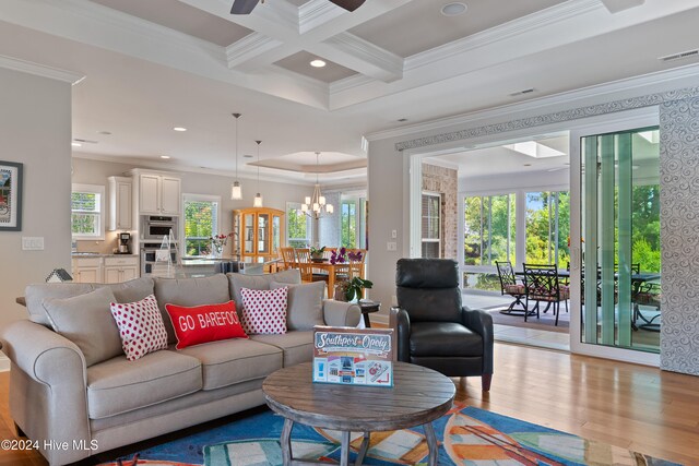 living area with light wood finished floors, visible vents, ornamental molding, beam ceiling, and coffered ceiling