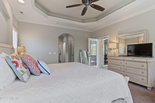 carpeted bedroom featuring arched walkways, visible vents, a raised ceiling, and ornamental molding