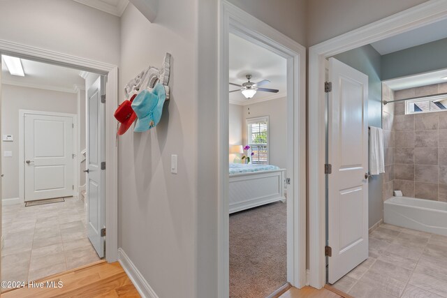 hall featuring crown molding and baseboards