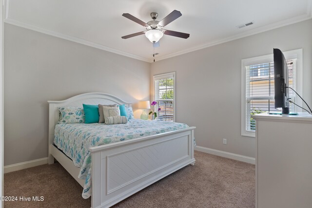 bedroom with visible vents, ceiling fan, baseboards, light colored carpet, and ornamental molding