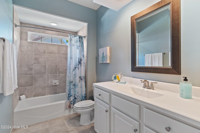 bathroom with vanity, shower / bath combination with curtain, toilet, and tile patterned floors