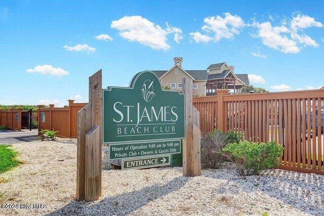 community / neighborhood sign featuring fence