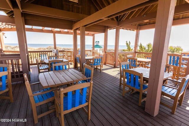 wooden deck with outdoor dining space and a water view