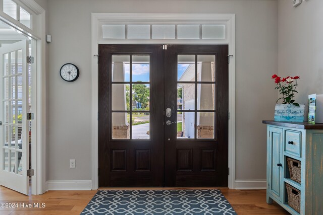 entryway with french doors, baseboards, and light wood finished floors