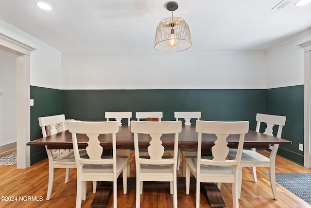 dining space with crown molding and hardwood / wood-style floors