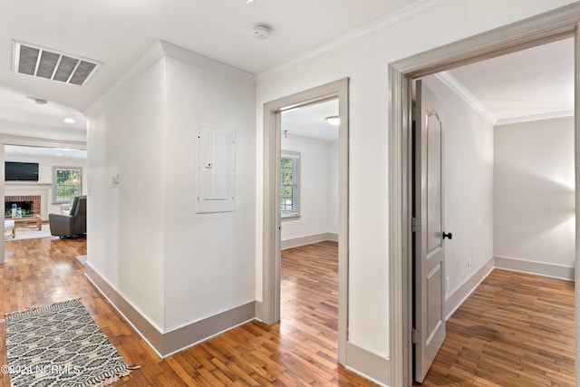 hallway with ornamental molding, electric panel, and hardwood / wood-style flooring