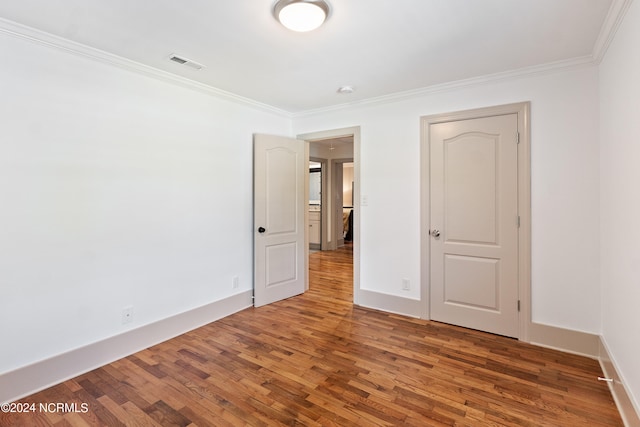 empty room featuring crown molding and dark hardwood / wood-style floors