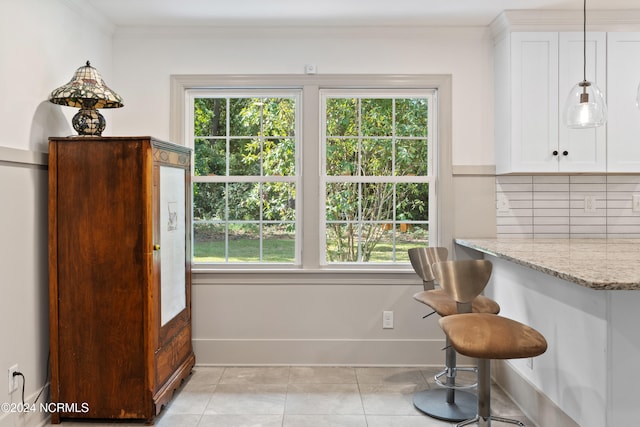 dining room featuring crown molding, plenty of natural light, and light tile patterned floors