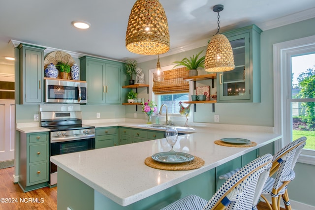 kitchen featuring sink, green cabinetry, kitchen peninsula, and stainless steel appliances