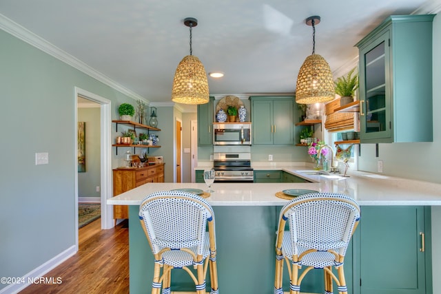 kitchen featuring sink, appliances with stainless steel finishes, kitchen peninsula, and decorative light fixtures