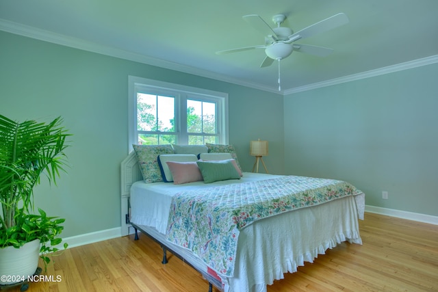 bedroom featuring light hardwood / wood-style floors, crown molding, and ceiling fan