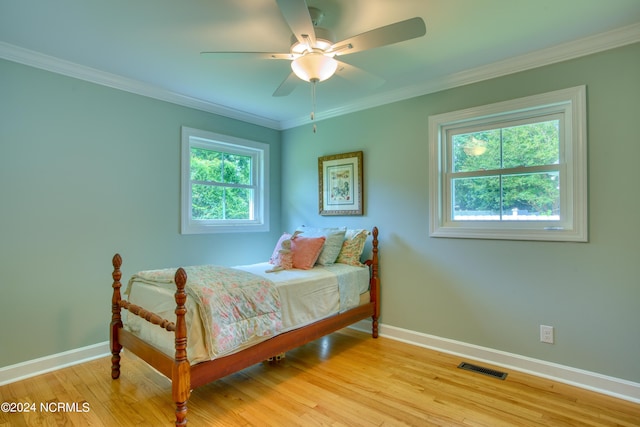 bedroom with ornamental molding, light hardwood / wood-style flooring, multiple windows, and ceiling fan