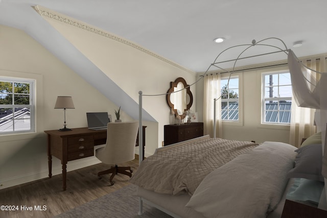 bedroom featuring multiple windows, hardwood / wood-style floors, and lofted ceiling