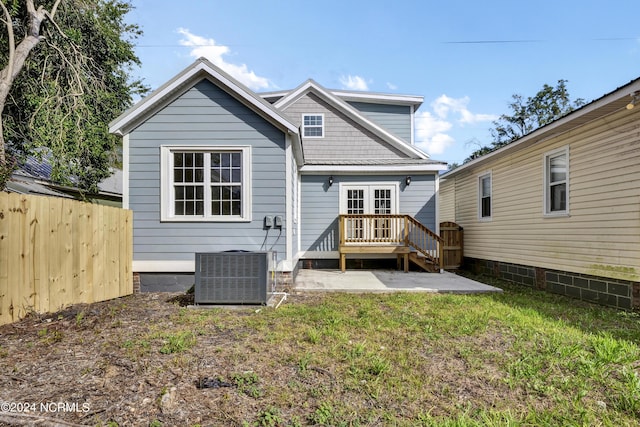 rear view of property with a lawn, central air condition unit, a patio area, and a deck