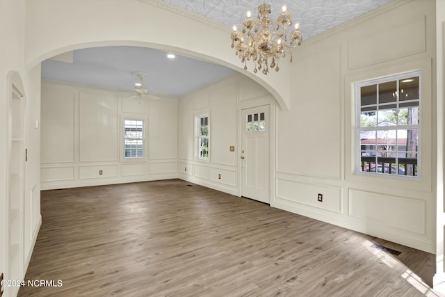 foyer with wood-type flooring, crown molding, and a wealth of natural light