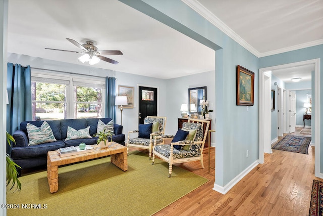 living room featuring ornamental molding, light hardwood / wood-style flooring, and ceiling fan