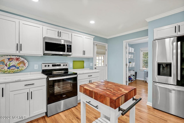 kitchen featuring crown molding, stainless steel appliances, light hardwood / wood-style flooring, and white cabinets