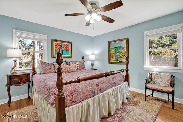 bedroom with light hardwood / wood-style flooring, multiple windows, and ceiling fan