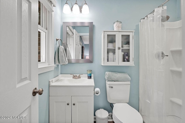 bathroom featuring vanity, toilet, and curtained shower