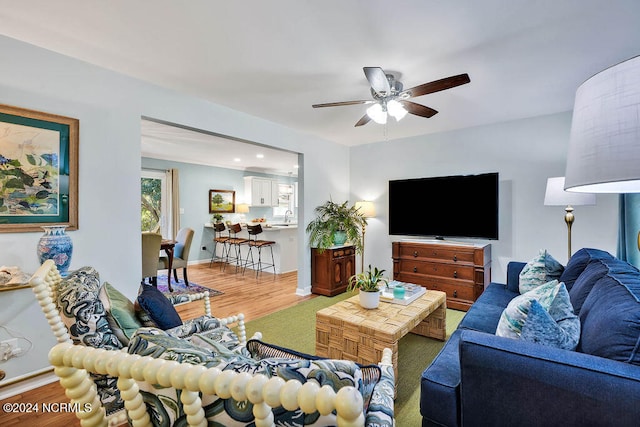 living room with hardwood / wood-style floors and ceiling fan