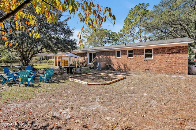 back of property with a patio and a fire pit