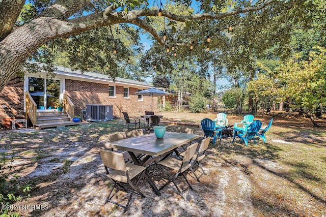 view of patio / terrace with a deck, cooling unit, and an outdoor fire pit