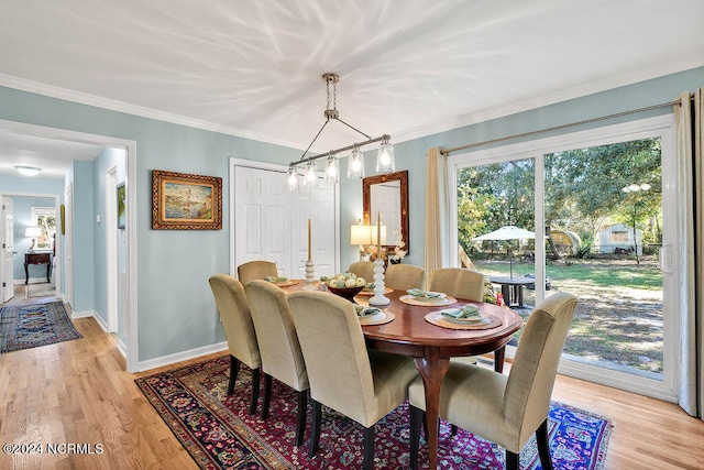 dining area with light hardwood / wood-style flooring and crown molding