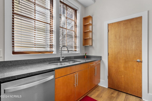 kitchen with light hardwood / wood-style flooring, stainless steel dishwasher, sink, and a wealth of natural light