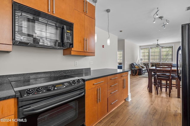 kitchen with black appliances, hanging light fixtures, dark hardwood / wood-style floors, and ceiling fan