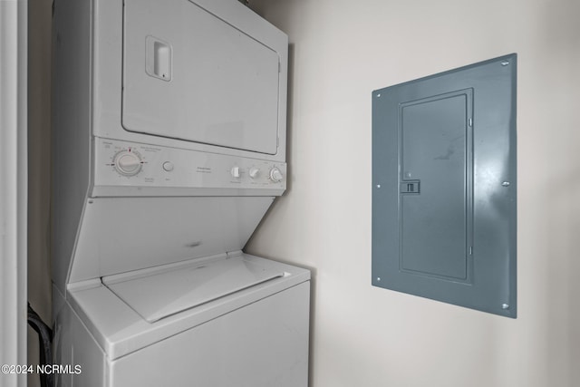 washroom featuring electric panel and stacked washer and clothes dryer