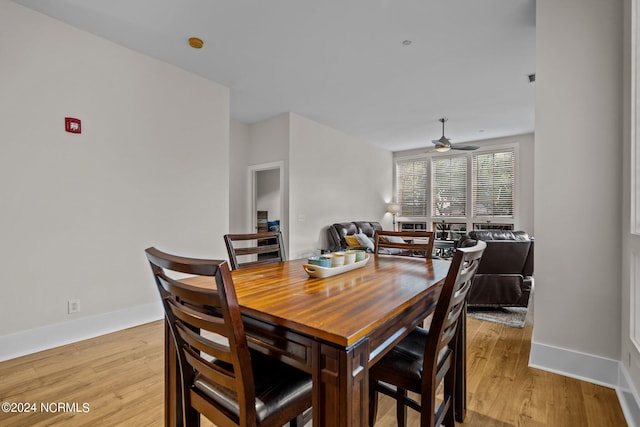 dining area with baseboards, light wood-style floors, and a ceiling fan