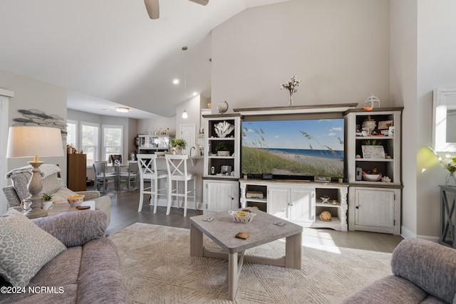 living room with ceiling fan, high vaulted ceiling, and hardwood / wood-style floors