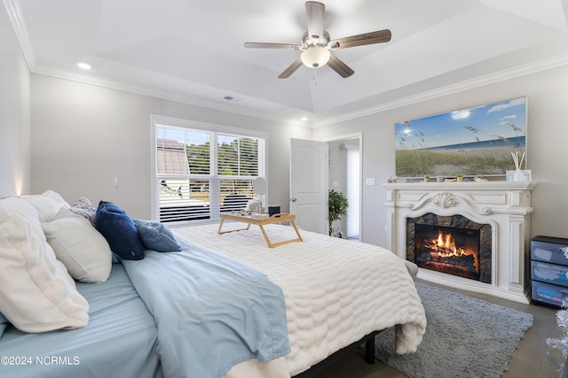 bedroom featuring ceiling fan, ornamental molding, and a tray ceiling