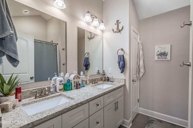 bathroom featuring vanity and lofted ceiling