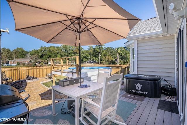 wooden deck with a fenced in pool