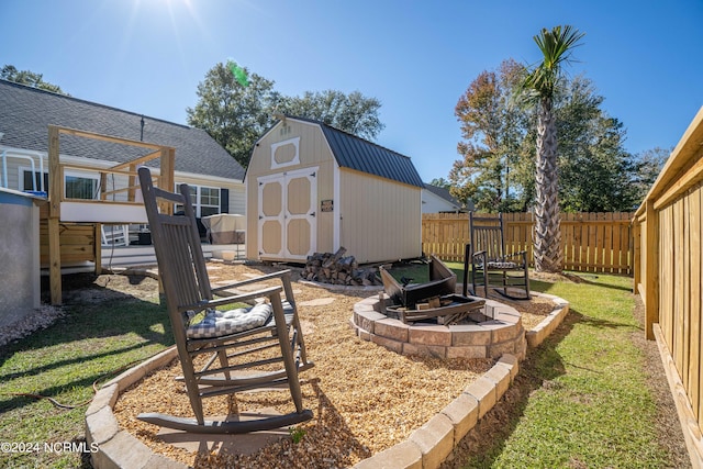 view of yard with a shed and a fire pit