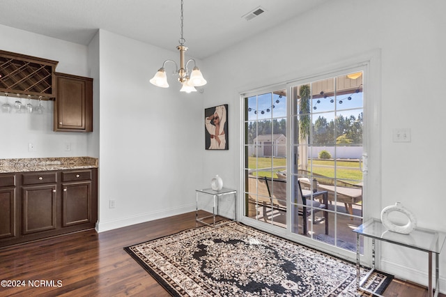 dining area featuring dark hardwood / wood-style floors and a chandelier