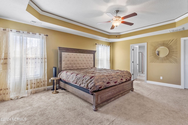 bedroom with ornamental molding, light colored carpet, a raised ceiling, a textured ceiling, and ceiling fan