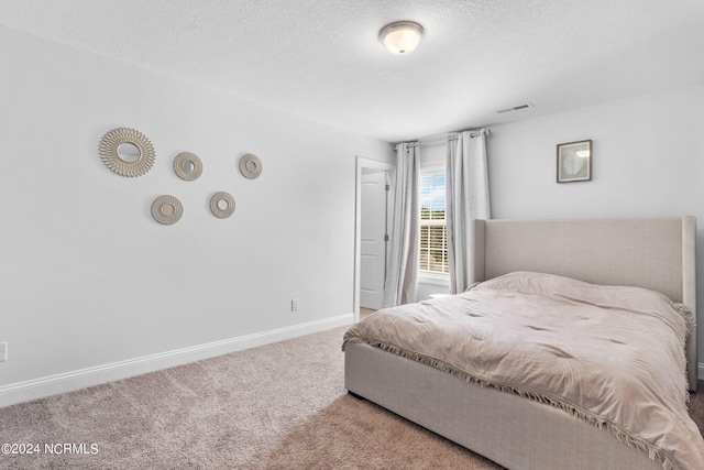 carpeted bedroom featuring a textured ceiling