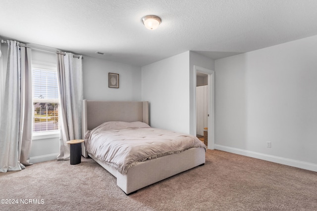 carpeted bedroom featuring a textured ceiling