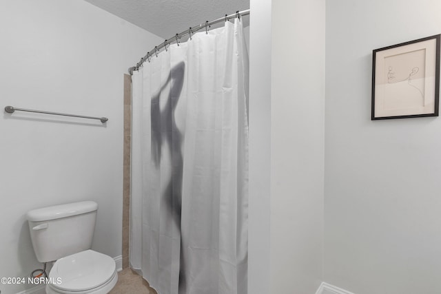 bathroom featuring toilet, a textured ceiling, and walk in shower