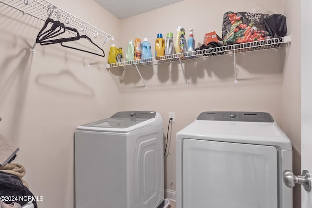 laundry room featuring a textured ceiling and separate washer and dryer