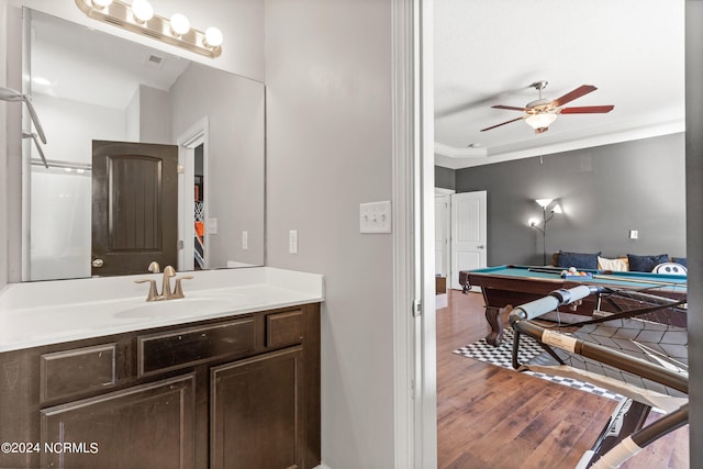 bathroom featuring hardwood / wood-style floors, crown molding, billiards, vanity, and ceiling fan