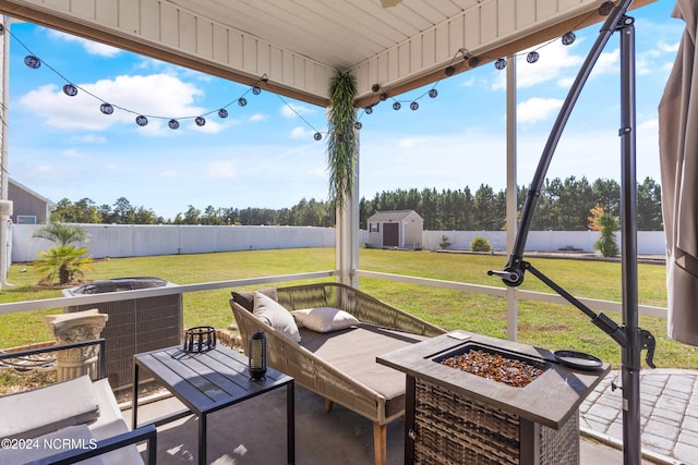 view of patio / terrace with cooling unit, a shed, and a fire pit