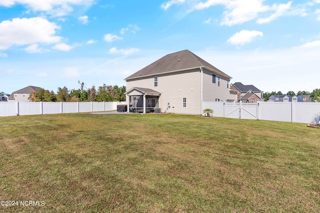 back of property with a lawn and a sunroom