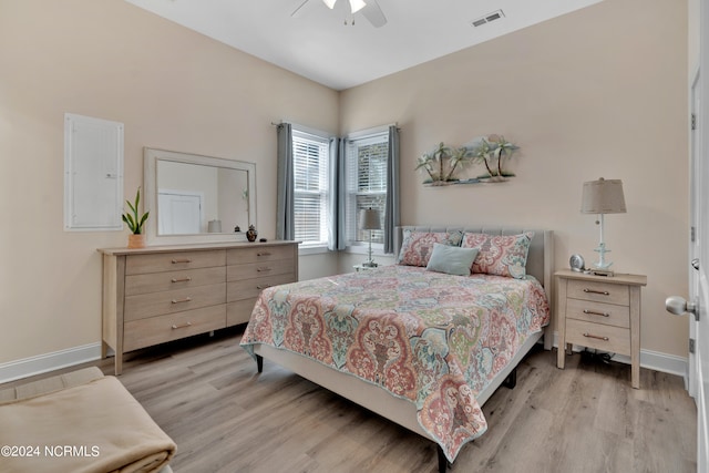 bedroom featuring electric panel, ceiling fan, and light hardwood / wood-style flooring