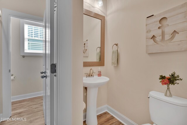 bathroom with hardwood / wood-style flooring, toilet, and sink