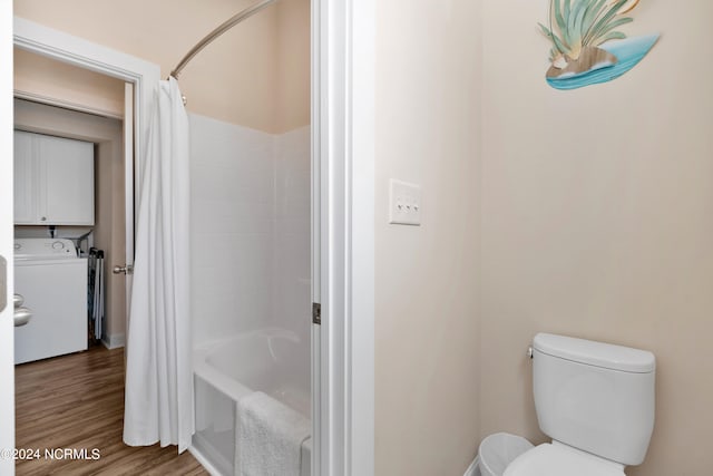 bathroom with toilet, hardwood / wood-style floors, shower / bath combo, and washer / dryer