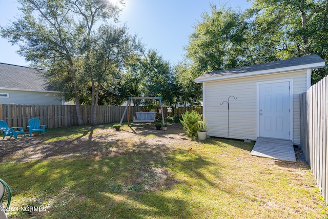 view of yard featuring a storage unit and a playground