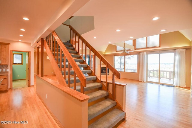 stairs with wood-type flooring and ceiling fan